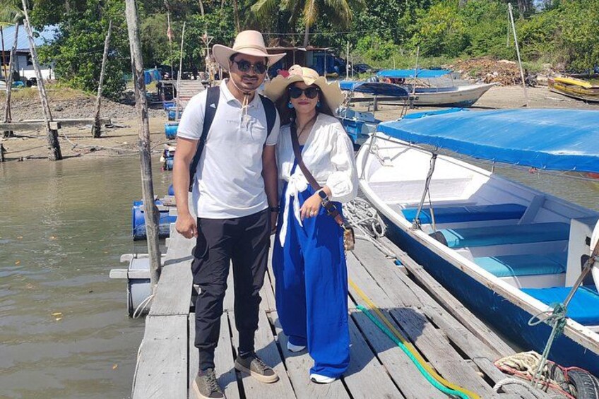 A wooden dock with boats, a person wearing a hat and sunglasses, and another person in a blue outfit. 3