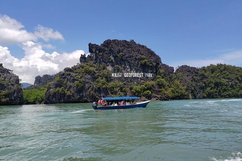 A boat with passengers on a clear day, surrounded by rocky cliffs and lush greenery, with the text 'KILINBI GEFOREST PARK' visible. 1