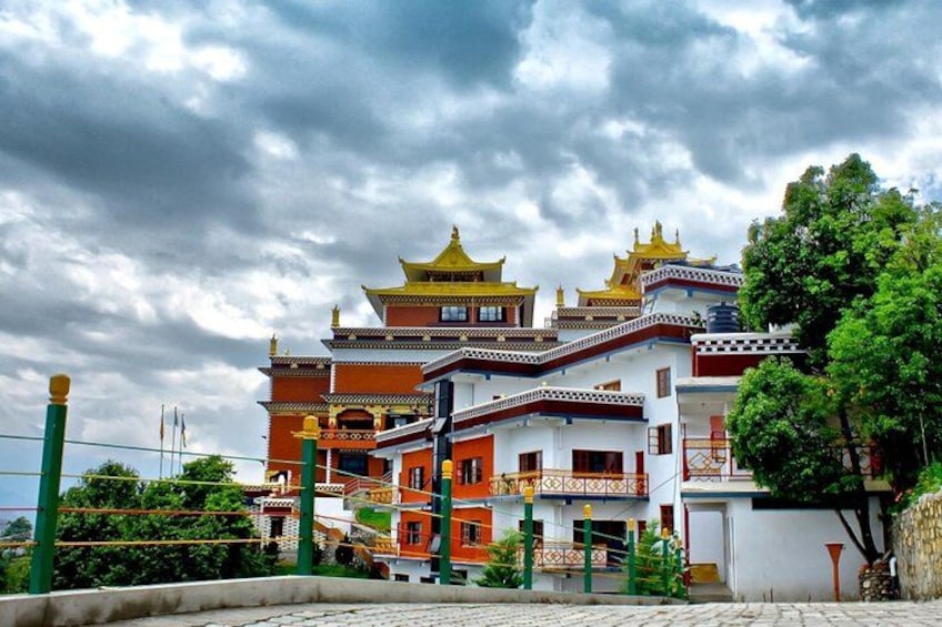 A traditional multi-tiered building with ornate roofs, surrounded by greenery and a cloudy sky. 2