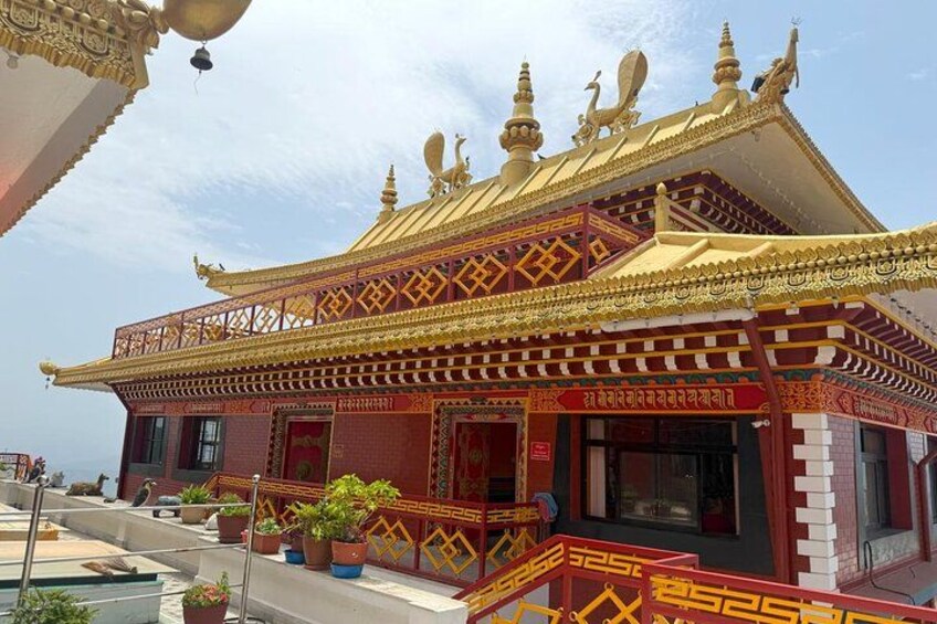 A traditional building with ornate golden roofs and red walls. 3