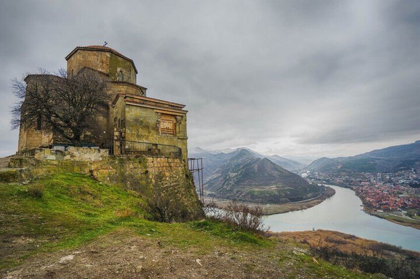 Un bâtiment historique situé sur une colline, dominant une rivière et une ville. 4