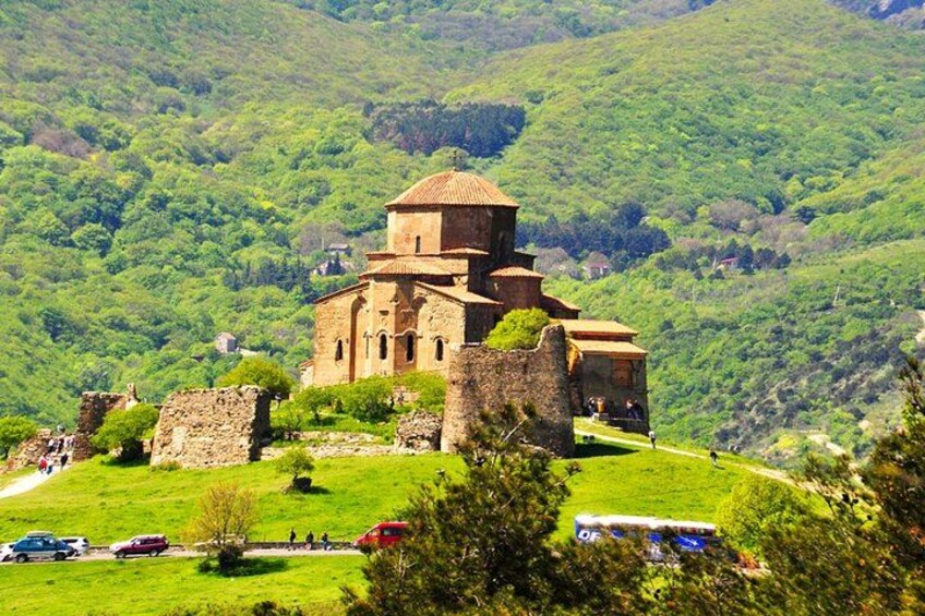 Une église historique dotée d’un clocher, entourée de collines verdoyantes. 3