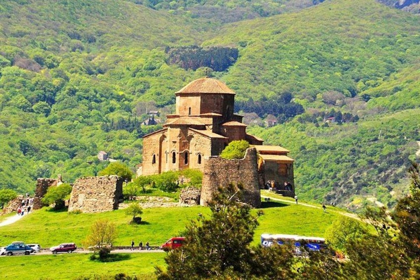 Une église historique dotée d’un clocher, entourée de collines verdoyantes. 3