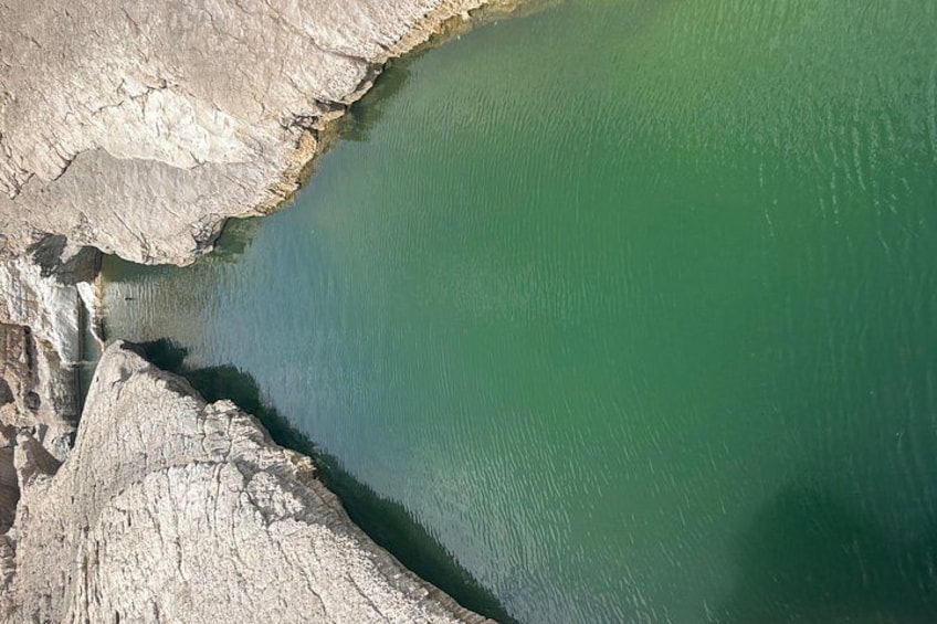 Una masa de agua verde bordeada por acantilados rocosos. 4