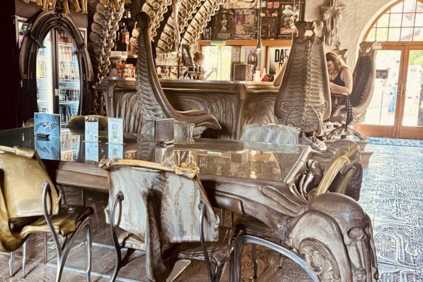 A bar with ornate furniture and a skeleton decoration. 1
