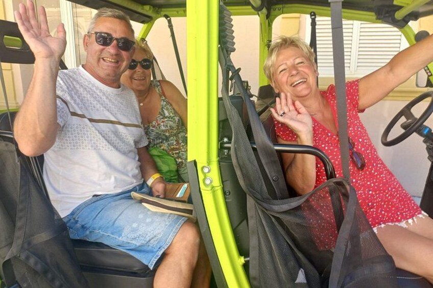 A person in a red polka dot dress seated in a vehicle with a steering wheel. 4
