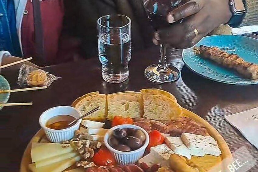 Una comida con pan, queso, aceitunas y una bebida. 3