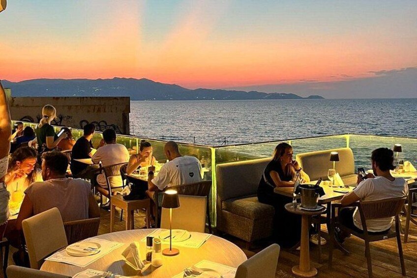 Vista del atardecer desde un restaurante con mesas y sillas, con vista al mar. 2