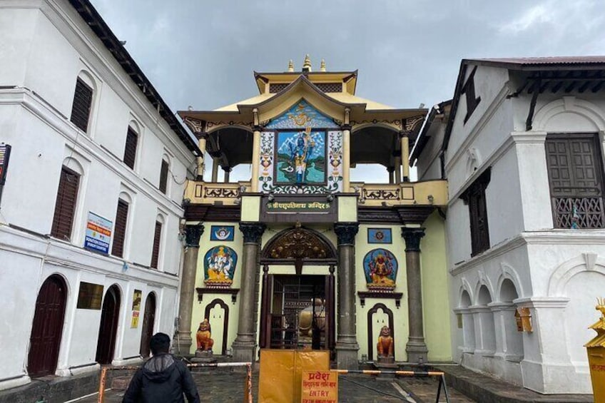 A traditional temple entrance with ornate decorations and a person standing in front. 4