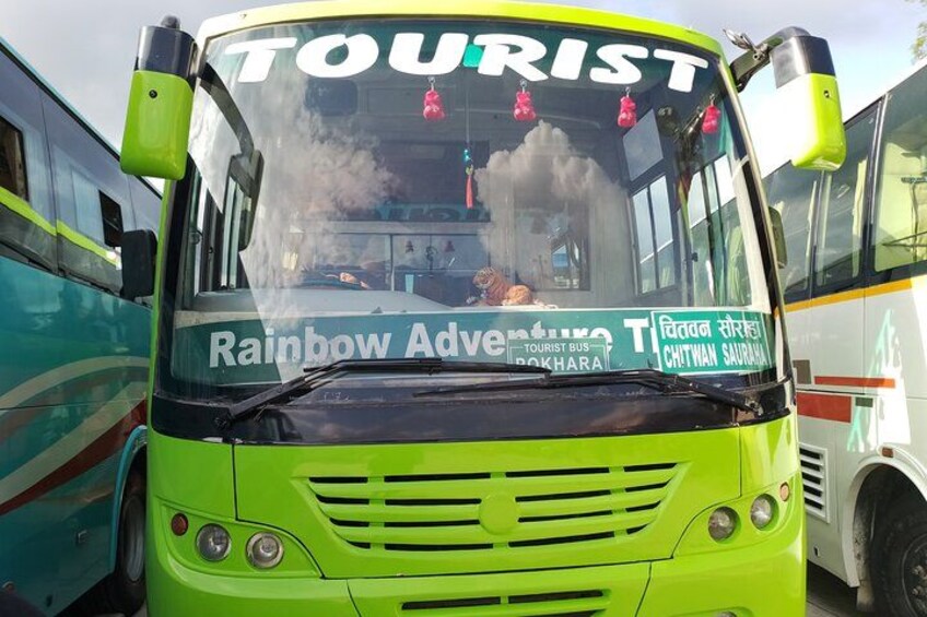 A green tourist bus with 'Rainbow Adventure' and 'Chitthan Saura' written on it. 2