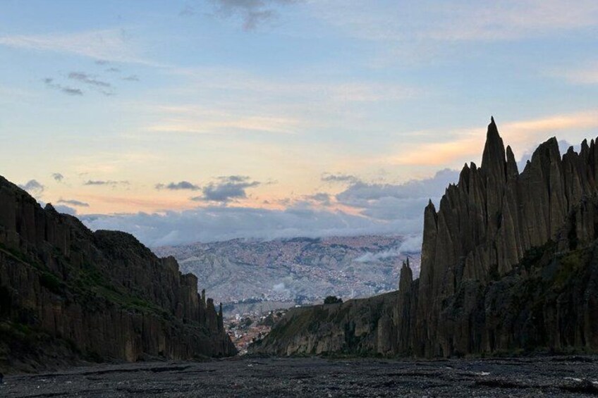 A canyon with steep rock walls and a distant view of a city. 4
