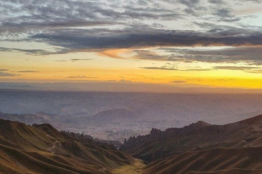 A mountainous landscape with a valley and a sunset. 2
