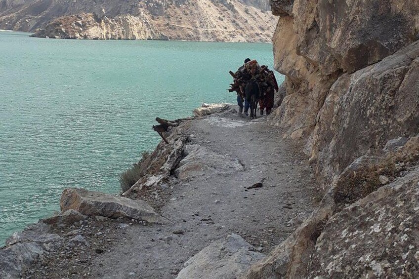 Una costa rocciosa con un gruppo di persone che cammina lungo un sentiero. 5