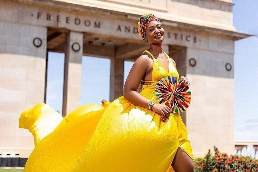 Una persona con un vestido amarillo de pie frente a un edificio con columnas y las palabras 'FREEDOM AND JUSTICE' escritas en él. 3