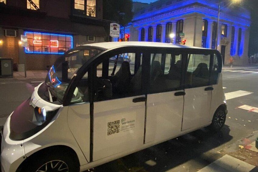 A white car parked on a city street at night. 2