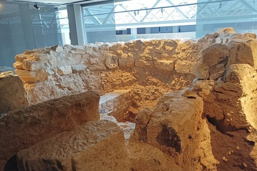Een archeologische plek met zichtbare ruïnes en een open ruimte in het midden. 2