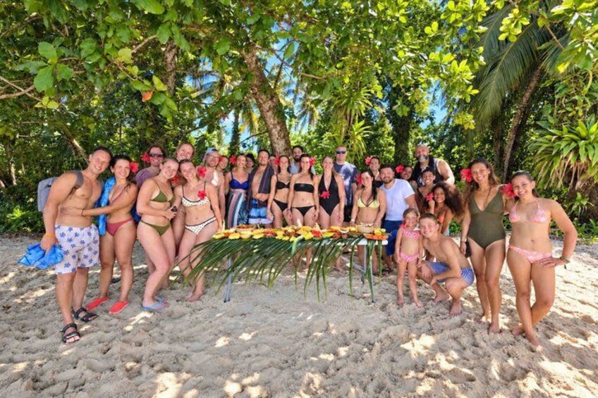 A group of people on a sandy beach with palm trees in the background. 4