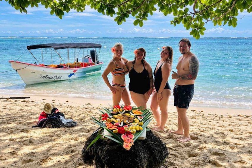 A beach with a boat named 'Amicable' and a fruit display. 5