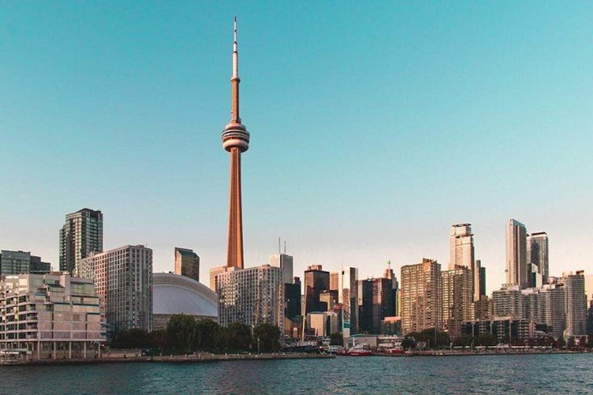 Une vue sur les toits d’une ville, avec une tour imposante, des bâtiments modernes et une étendue d’eau. 5