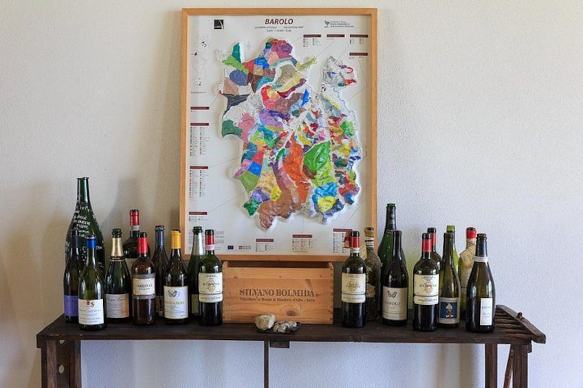 A wine rack with various bottles and a framed map on the wall. 4