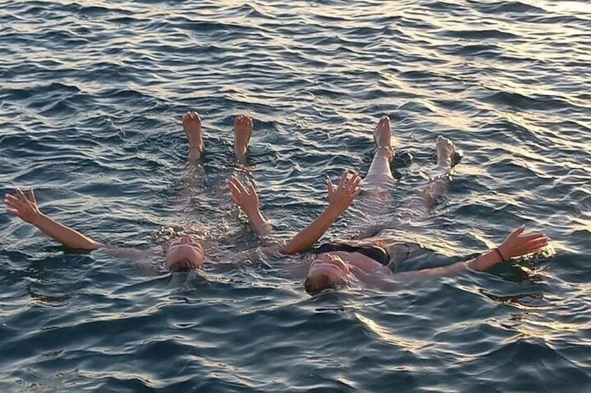 A group of people floating on water with their arms spread out. 4
