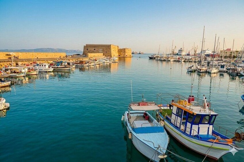 Un puerto con barcos, un castillo y cielo despejado. 1