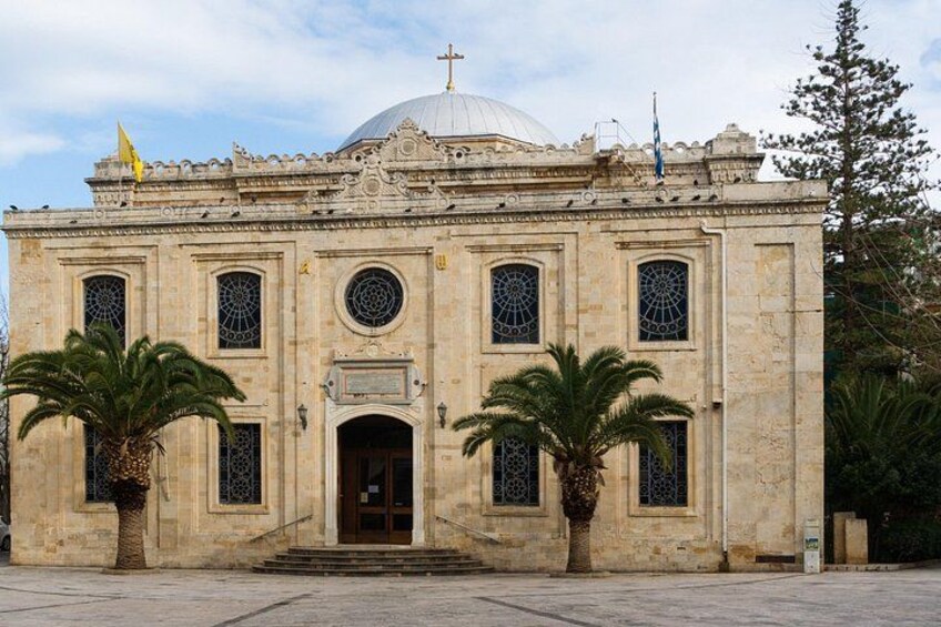 Un edificio histórico con una cúpula, ventanas arqueadas y palmeras en primer plano. 3