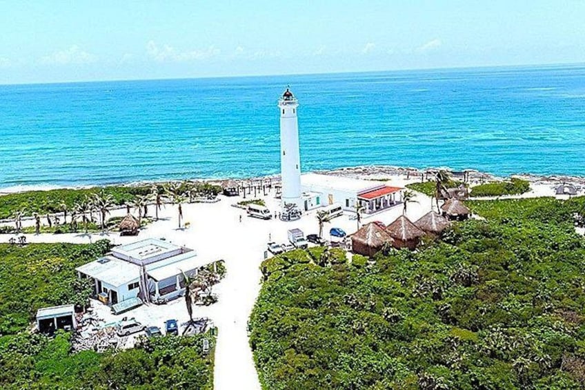 A lighthouse, beach, and surrounding greenery. 4