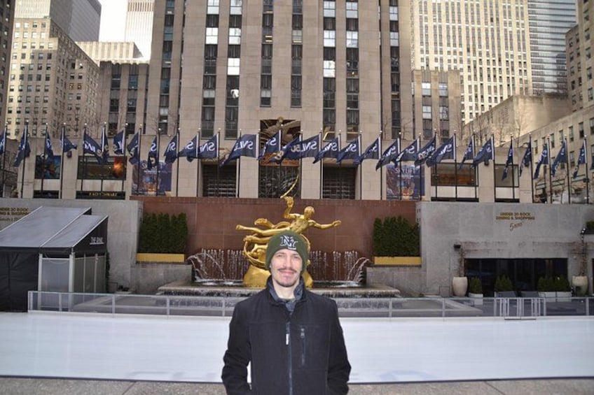 A person standing in front of a building with a fountain and flags. 2