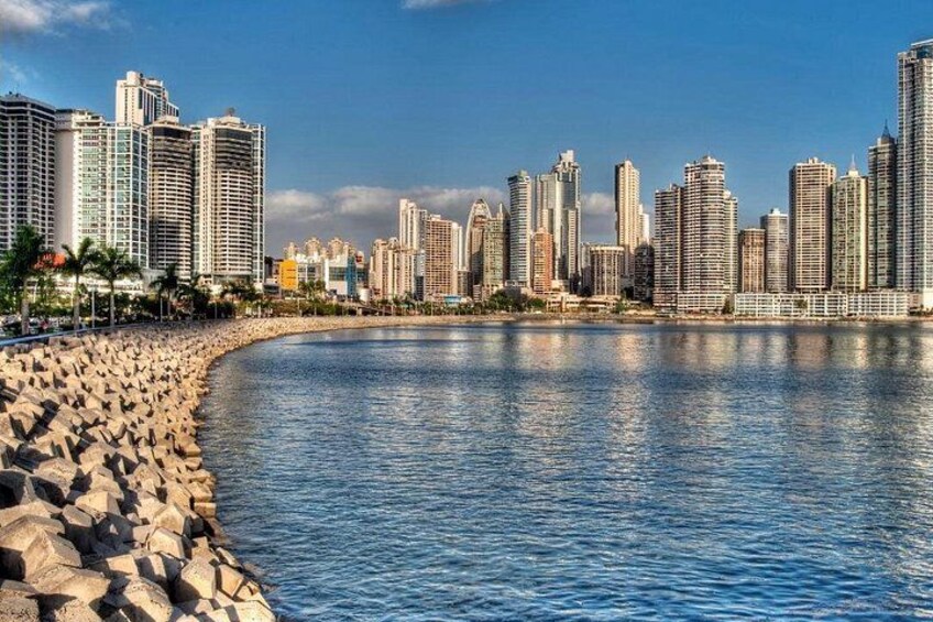 A coastal cityscape with a rocky beach and high-rise buildings. 3