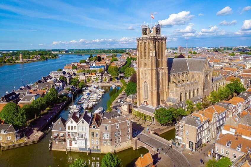 Ein Fluss mit Booten, ein hoher Turm und eine historische Kirche. 1