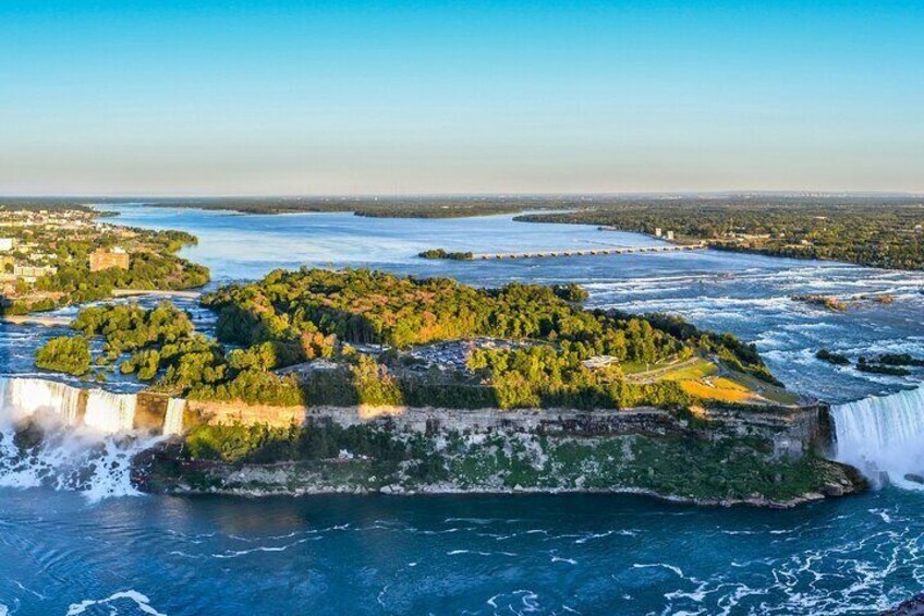 Une grande cascade se déversant sur une île rocheuse, elle-même entourée d’eau. 3