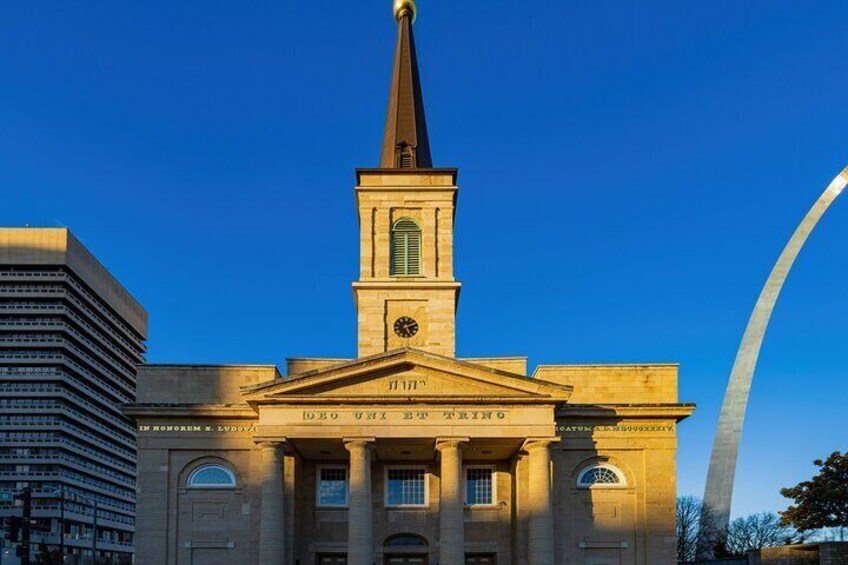 A historic building with a clock tower, columns, and arched windows. 2