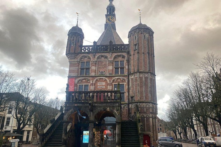 A historic building with a clock tower, arched windows, and a staircase leading to the entrance. 3