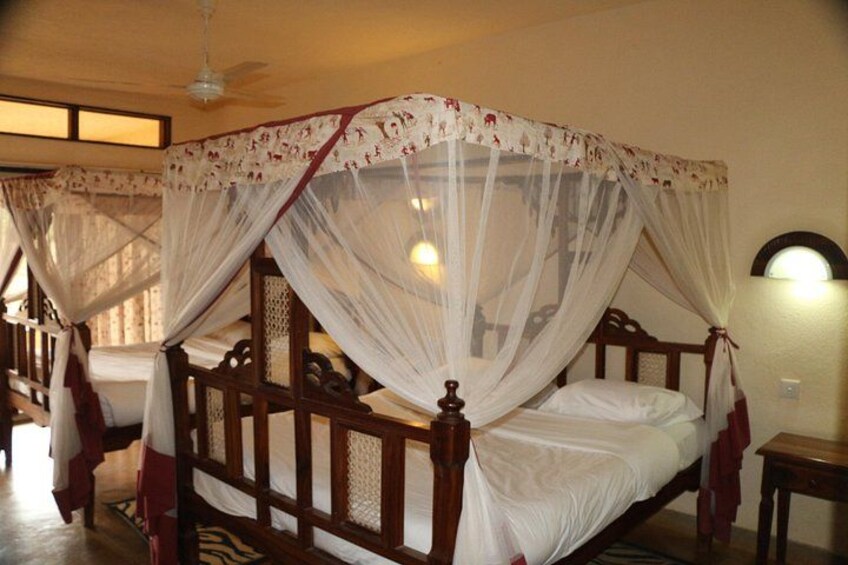 A four-poster bed with a canopy, wooden frame, and white bedding. 5