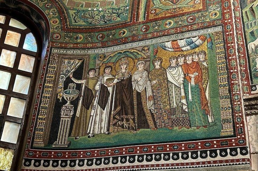 A mosaic with figures in elaborate attire, a central figure holding a staff, and a decorative border. 3