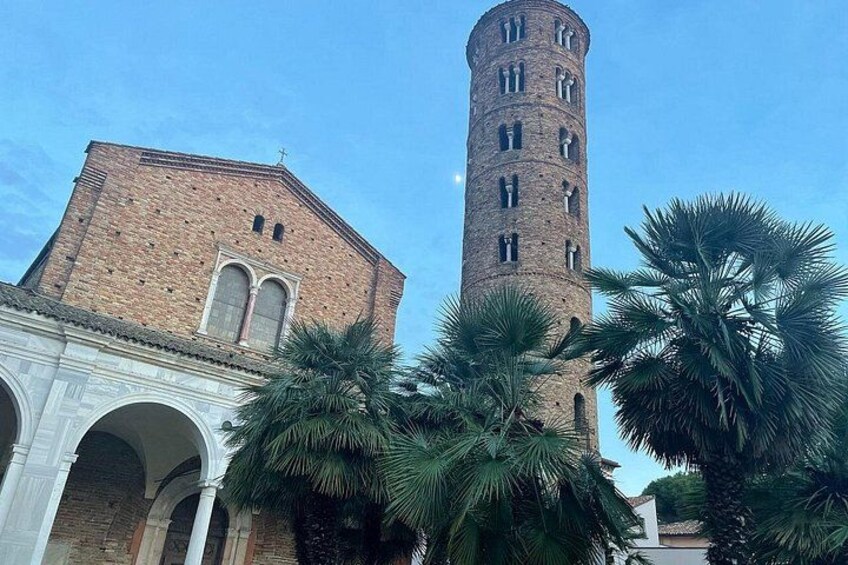 A historic building with a tall tower and arches. 2