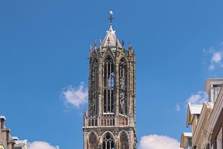 A tall, Gothic-style tower with intricate stonework and a weather vane on top. 3
