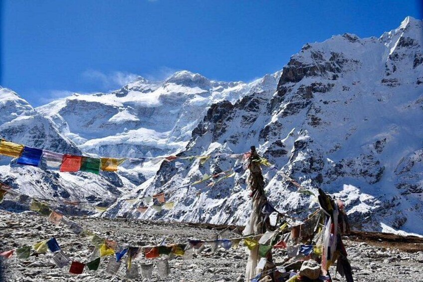 A mountainous landscape with snow-covered peaks and colorful prayer flags. 1