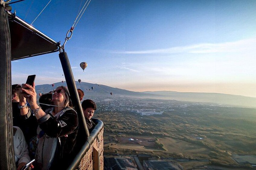 Een luchtballonvaart met passagiers die foto's maken. 2