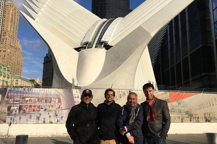 Un groupe de personnes se tient devant une structure architecturale moderne, dont le design incurvé est particulièrement original. 3