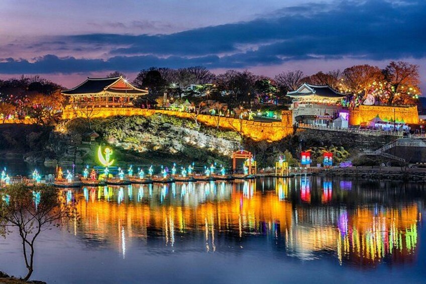 A traditional Chinese building with illuminated structures and a reflection in the water. 1