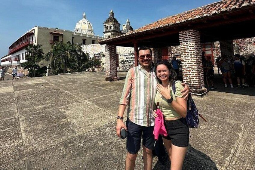 Un couple se tient devant un bâtiment historique doté de coupoles et d’un toit recouvert de tuiles. 5