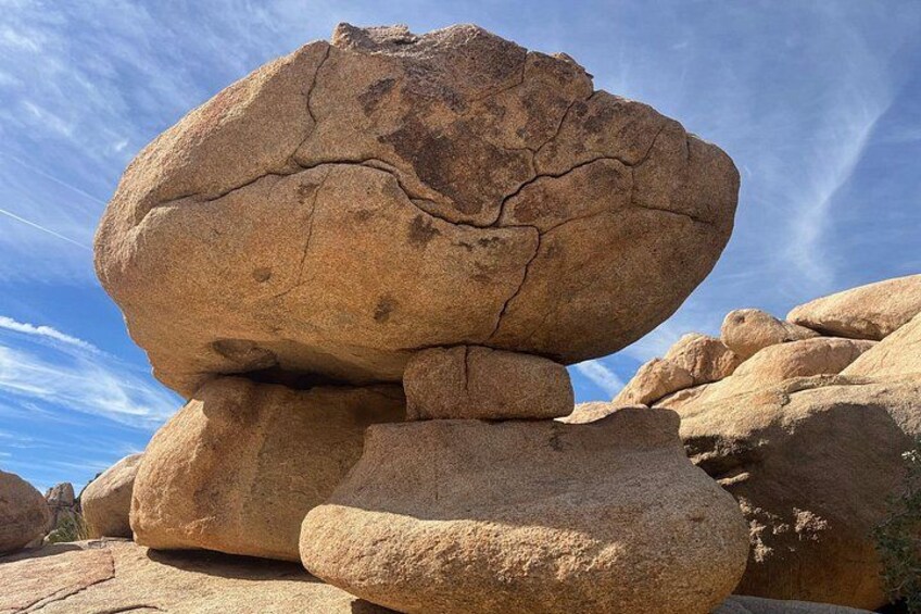 A large balanced rock formation with a clear sky in the background. 4