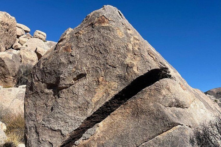 A large rock formation with a prominent arch and surrounding boulders. 3