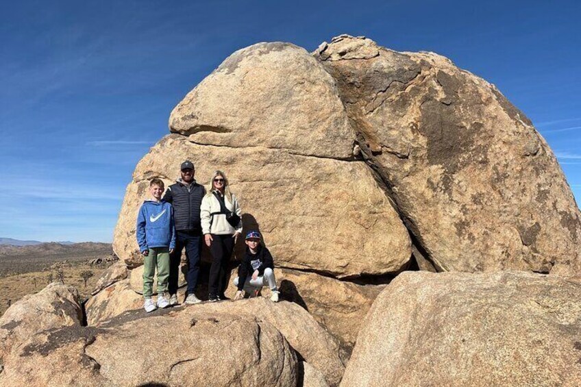 A large rock formation with a group of people standing on it. 5