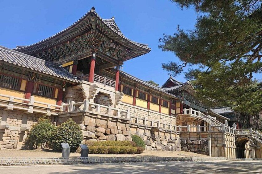 A traditional Chinese building with ornate architecture, including a multi-tiered roof and red pillars. 1