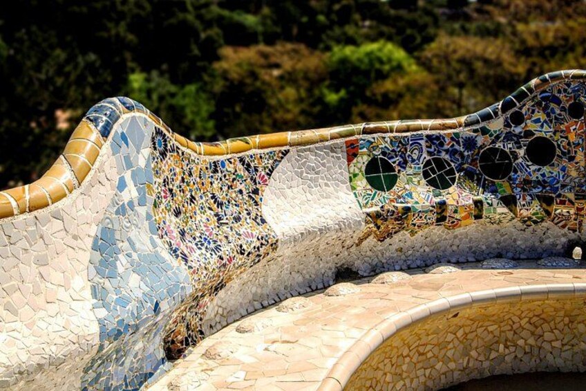 A mosaic wall with a wavy design, featuring a variety of colors and shapes. 4