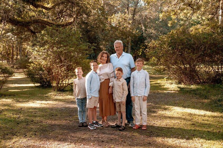 Una famiglia di sei in un parco boschivo con un sentiero. 4