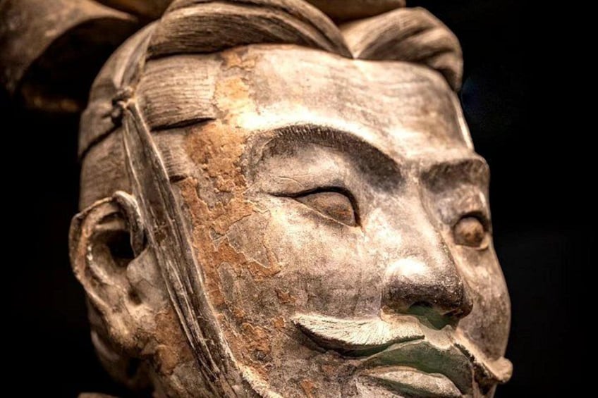 Una escultura de madera desgastada con intrincados grabados, posiblemente de importancia histórica o cultural. 5